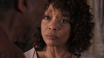 Movie still from “The Bucket List” (2007), directed by Rob Reiner – An older woman with curly black hair looking at the camera; Close Up shot, Over the shoulder angle