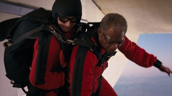 Movie still from “The Bucket List” (2007), directed by Rob Reiner – A man in a red jacket is on a parachute; Medium shot, Low angle