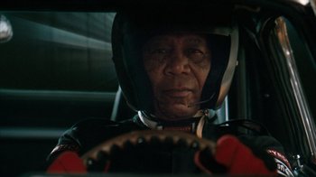 Movie still from “The Bucket List” (2007), directed by Rob Reiner – An older man in a racing suit sitting in a car; Close Up shot, Low angle