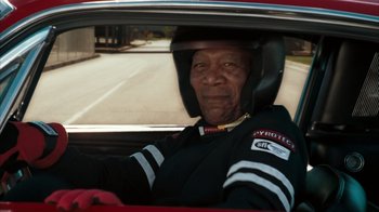 Movie still from “The Bucket List” (2007), directed by Rob Reiner – An older man wearing a motorcycle helmet driving a car; Close Up shot, Over the shoulder angle