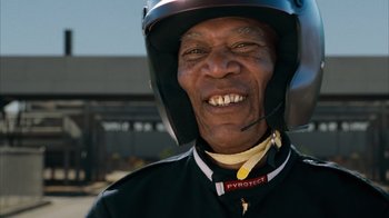 Movie still from “The Bucket List” (2007), directed by Rob Reiner – An older man wearing a motorcycle helmet and smiling for the camera; Close Up shot, Low angle