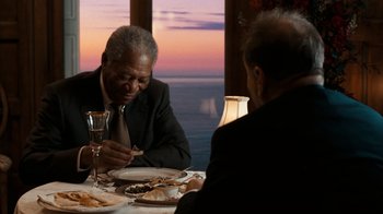 Movie still from “The Bucket List” (2007), directed by Rob Reiner – Two men sitting at a dinner table with a glass of wine; Medium shot, Over the shoulder angle