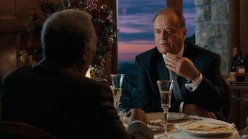 Movie still from “The Bucket List” (2007), directed by Rob Reiner – Two men sitting at a dinner table talking to each other; Medium shot, Over the shoulder angle