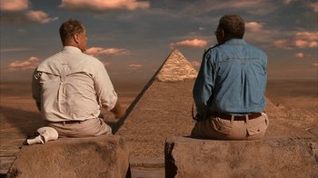 Movie still from “The Bucket List” (2007), directed by Rob Reiner – Two men sitting on rocks looking at a pyramid in the desert; Wide shot, Low angle