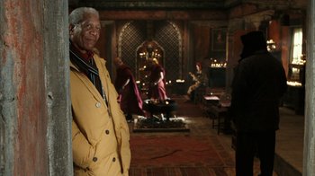 Movie still from “The Bucket List” (2007), directed by Rob Reiner – An older man in a yellow jacket standing in front of a fireplace; Medium shot, Over the shoulder angle