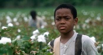 Movie still from “The Butler” (2013), directed by Lee Daniels – A young boy standing in a field of cotton; Close Up shot, High angle