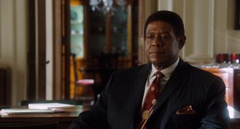 Movie still from “The Butler” (2013), directed by Lee Daniels – A man in a suit and tie sitting at a table; Close Up shot, Over the shoulder angle
