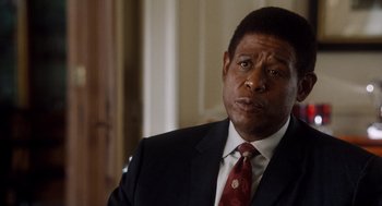 Movie still from “The Butler” (2013), directed by Lee Daniels – A man wearing a suit and tie in front of a wall; Close Up shot, Over the shoulder angle
