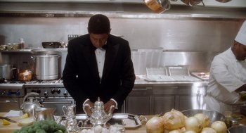Movie still from “The Butler” (2013), directed by Lee Daniels – A man in a kitchen preparing food on top of a counter; Medium shot, High angle