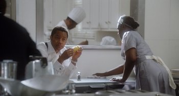 Movie still from “The Butler” (2013), directed by Lee Daniels – A man and a woman in a kitchen eating a piece of fruit; Medium shot, Low angle