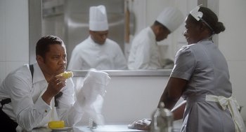 Movie still from “The Butler” (2013), directed by Lee Daniels – Two chefs are sitting at a table in a kitchen; Medium shot, Over the shoulder angle