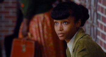 Movie still from “The Butler” (2013), directed by Lee Daniels – A woman with a black hair style and a green jacket; Close Up shot, Over the shoulder angle