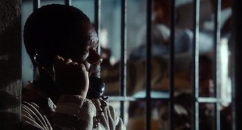 Movie still from “The Butler” (2013), directed by Lee Daniels – A man talking on a cell phone next to a jail cell; Close Up shot, Over the shoulder angle