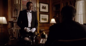 Movie still from “The Butler” (2013), directed by Lee Daniels – A man in a tuxedo standing in front of a table; Medium shot, Over the shoulder angle