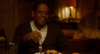 Movie still from “The Butler” (2013), directed by Lee Daniels – A man sitting in front of a plate of food with a knife and a fork; Medium shot, Over the shoulder angle