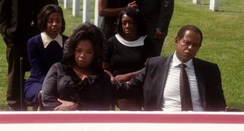 Movie still from “The Butler” (2013), directed by Lee Daniels – A group of people sitting next to each other in front of an american flag; Medium shot, High angle