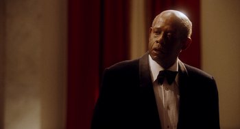 Movie still from “The Butler” (2013), directed by Lee Daniels – A man in a suit and bow tie standing in front of a red curtain; Close Up shot, Low angle