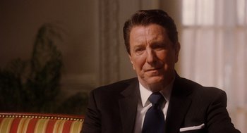Movie still from “The Butler” (2013), directed by Lee Daniels – A man in a suit and tie sitting in a chair; Close Up shot, Over the shoulder angle