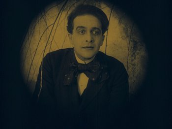 Movie still from “The Cabinet of Dr. Caligari” (1920), directed by Robert Wiene – A man in a suit and a bow tie; Medium shot, Low angle