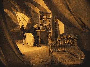 Movie still from “The Cabinet of Dr. Caligari” (1920), directed by Robert Wiene – A man sitting at a desk in a room; Wide shot, High angle