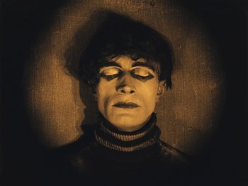 Movie still from “The Cabinet of Dr. Caligari” (1920), directed by Robert Wiene – A man with his eyes closed and his head tilted to the side; Medium shot, Overhead angle