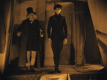 Movie still from “The Cabinet of Dr. Caligari” (1920), directed by Robert Wiene – A man and a woman standing next to each other; Wide shot, Low angle