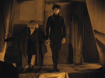 Movie still from “The Cabinet of Dr. Caligari” (1920), directed by Robert Wiene – A woman and a man standing next to each other; Wide shot, High angle