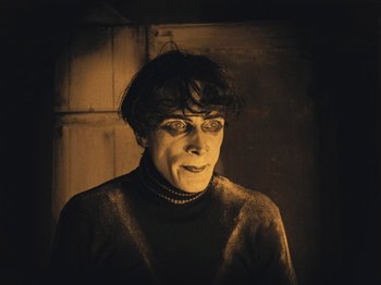 Movie still from “The Cabinet of Dr. Caligari” (1920), directed by Robert Wiene – A man in a black sweater is posing for a picture; Medium shot, High angle