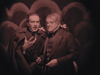 Movie still from “The Cabinet of Dr. Caligari” (1920), directed by Robert Wiene – A couple of men standing next to each other; Medium shot, High angle