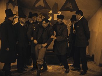 Movie still from “The Cabinet of Dr. Caligari” (1920), directed by Robert Wiene – A group of men standing next to each other; Wide shot, High angle