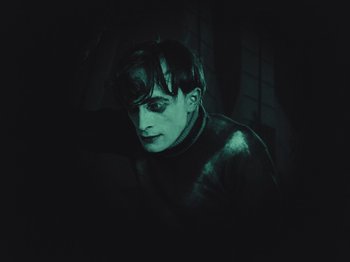 Movie still from “The Cabinet of Dr. Caligari” (1920), directed by Robert Wiene – A man in a black jacket is looking at the camera; Close Up shot, High angle