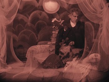 Movie still from “The Cabinet of Dr. Caligari” (1920), directed by Robert Wiene – A man and a woman sitting on a couch; Wide shot, High angle