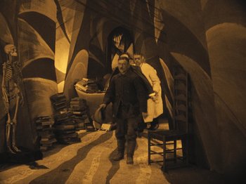 Movie still from “The Cabinet of Dr. Caligari” (1920), directed by Robert Wiene – A man and a woman standing in a room; Wide shot, High angle
