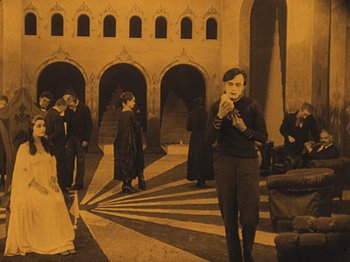 Movie still from “The Cabinet of Dr. Caligari” (1920), directed by Robert Wiene – A group of people standing around in a building; Wide shot, High angle