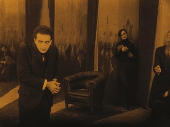 Movie still from “The Cabinet of Dr. Caligari” (1920), directed by Robert Wiene – A man and a woman standing next to each other in a room; Wide shot, High angle