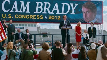 Movie still from “The Campaign” (2012), directed by Jay Roach – A man standing at a podium in front of a crowd of onlookers; Wide shot, High angle