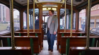 Movie still from “The Campaign” (2012), directed by Jay Roach – A man standing on a train looking into a train car; Wide shot, Low angle