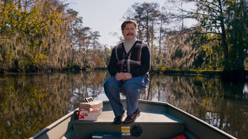 Movie still from “The Campaign” (2012), directed by Jay Roach – A man sitting on the back of a boat; Wide shot, Low angle
