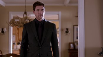 Movie still from “The Campaign” (2012), directed by Jay Roach – A man in a suit and tie standing in a room; Medium shot, Low angle