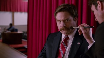 Movie still from “The Campaign” (2012), directed by Jay Roach – A man in a suit and tie with a brush in his mouth; Close Up shot, Low angle