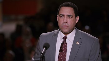 Movie still from “The Campaign” (2012), directed by Jay Roach – A man wearing a suit and tie standing in front of a microphone; Close Up shot, Over the shoulder angle