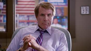 Movie still from “The Campaign” (2012), directed by Jay Roach – A man sitting in an office chair with his hands clasped together; Medium shot, High angle