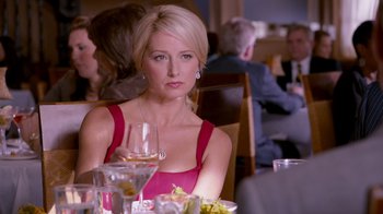 Movie still from “The Campaign” (2012), directed by Jay Roach – A woman sitting at a table with a glass of wine in front of her; Close Up shot, Over the shoulder angle