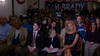 Movie still from “The Campaign” (2012), directed by Jay Roach – A group of people sitting in front of an audience; Medium shot, High angle