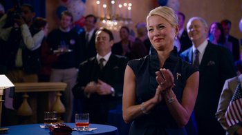 Movie still from “The Campaign” (2012), directed by Jay Roach – A woman clapping in front of a group of people at an event; Medium shot, Over the shoulder angle