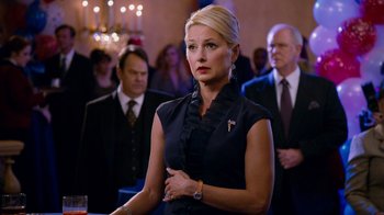 Movie still from “The Campaign” (2012), directed by Jay Roach – A woman standing in front of a crowd of people; Close Up shot, Over the shoulder angle