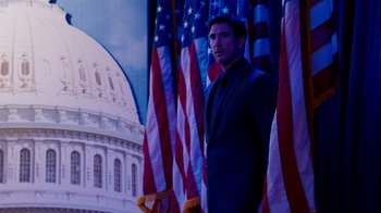 Movie still from “The Campaign” (2012), directed by Jay Roach – A man standing in front of american flags and capitol building; Medium shot, Over the shoulder angle