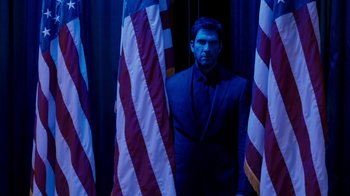 Movie still from “The Campaign” (2012), directed by Jay Roach – A man standing in front of a bunch of american flags; Medium shot, Low angle