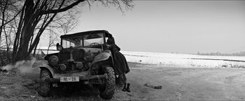 Movie still from “The Captain” (2017), directed by Robert Schwentke – An old truck is parked on the side of the road; Wide shot, Low angle