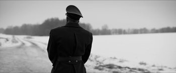 Movie still from “The Captain” (2017), directed by Robert Schwentke – A man in a military uniform looking out over a snow covered field; Medium shot, Low angle